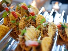 food is displayed on silver trays at a party or function event, including appetizers and condiments