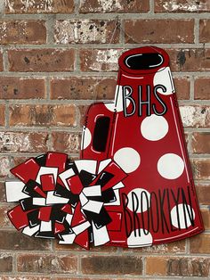 a red and white vase sitting on top of a brick wall