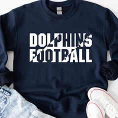 a blue sweatshirt with the words dolphins football printed on it, next to sneakers and a pair of jeans