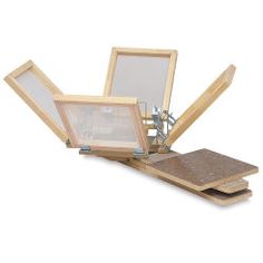 an open laptop computer sitting on top of a wooden stand with two pictures in it