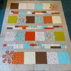 a patchwork quilt is displayed on the floor