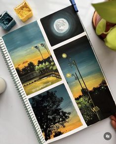 an open notebook with pictures of trees and street lights on it next to a cup of coffee