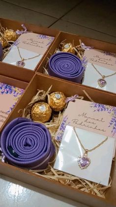 four boxes filled with purple and gold items