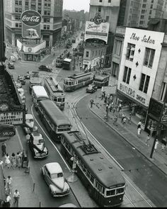 an old black and white photo of buses on a city street