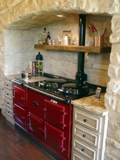 a red stove top oven sitting inside of a kitchen