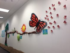 the wall is decorated with paper butterflies and trees