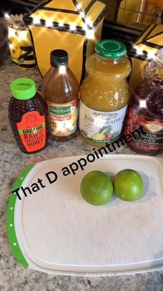 two limes on a cutting board next to some condiments and honey bottles