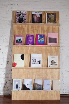 a bookshelf filled with lots of books on top of a hard wood floor