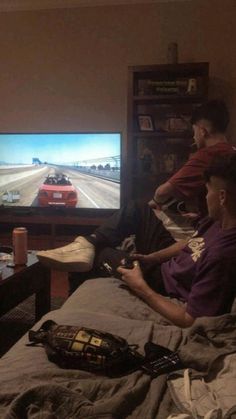 two men playing video games in their living room with the tv turned on and one man holding a remote control