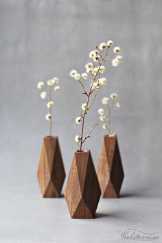 three wooden vases with white flowers in them