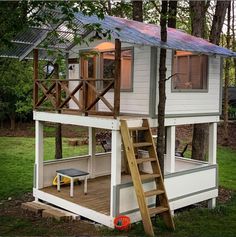 a small white house with a deck and stairs