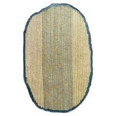 an oval shaped rug with blue trim on the bottom and green border, against a white background