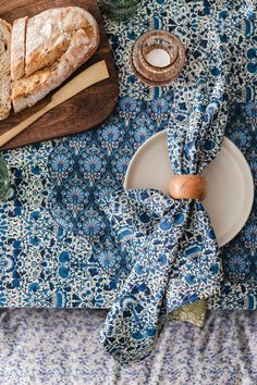 a table topped with bread and other food on top of a blue cloth covered table