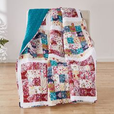 a bed with a colorful quilt on top of it