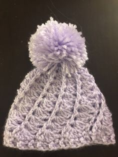 a crocheted hat with a pom - pom on the top and bottom