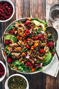 a salad with chicken, raspberries, avocado and cranberries