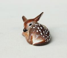 a small deer figurine sitting on top of a white cloth covered tablecloth