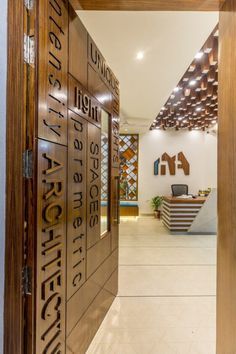 the entrance to an office building with wood paneling and metal lettering on the doors