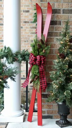 a pair of skis are tied to the side of a building with christmas decorations