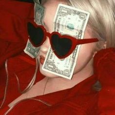 a woman with heart shaped sunglasses and money sticking out of her eyes