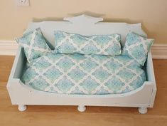 a bed made out of an old dollhouse with pillows on it and a pillow case in the middle