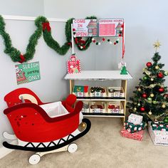 a room decorated for christmas with toys and presents on the floor, including a sleigh