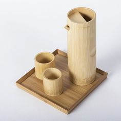 a bamboo container and two cups on a tray