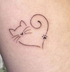 a small cat tattoo on the side of a woman's thigh, with black ink