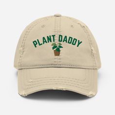 a tan hat with the words plant daddy on it and a potted plant in green