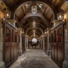 two horses are standing in the middle of an arched hallway with chandeliers on either side