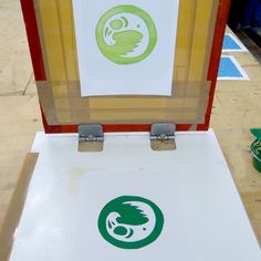 an open suitcase sitting on top of a wooden floor next to a green and white sign