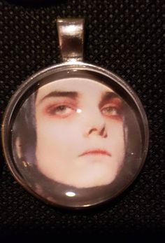 a close up of a person's face in a glass pendant