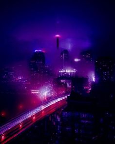 the city skyline is lit up in purple and red lights as traffic passes by at night