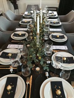 the table is set with black and gold place settings