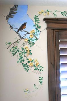 a bird sitting on top of a tree branch painted on the side of a wall