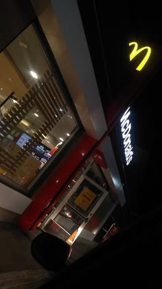 a mcdonald's restaurant at night with the neon sign lit up