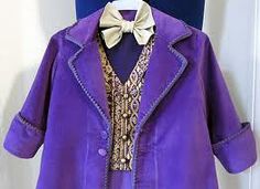 a purple coat with a white bow tie is hanging on a blue wall next to a mannequin's head