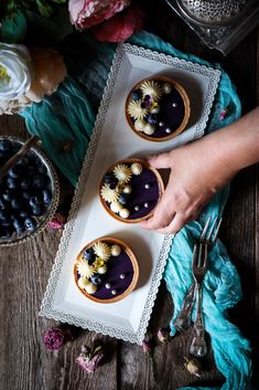 two desserts with blueberries are on a tray