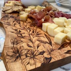 a cutting board with cheese and meat on it