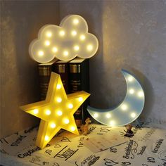 a light up star and moon sitting on top of a table next to a stack of books