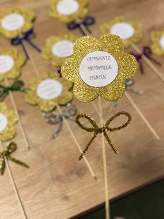 there are many gold flowers on sticks with name tags attached to them that say congratulations mother's day