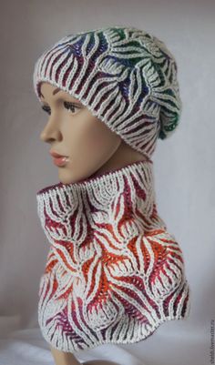 a mannequin head wearing a multicolored knitted scarf and beanie