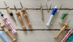 several different types of sewing needles on a wooden surface