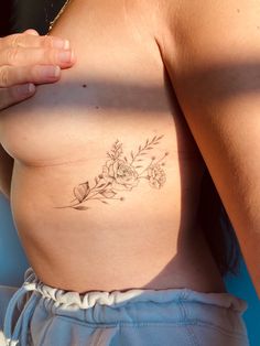 a close up of a person's breast with flowers on it and the bottom part of her stomach