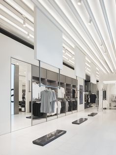 an empty clothing store with clothes on racks