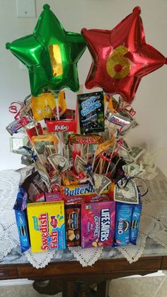 a table topped with lots of candy and star shaped foil balloons on top of it