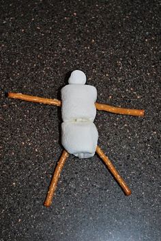 a small wooden stick with two marshmallows on it sitting on the ground