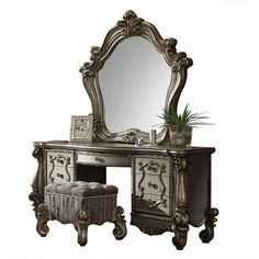 an ornate vanity with mirror and stool is shown in this image, it has a plant on top