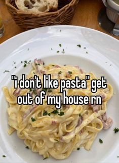 a white plate topped with pasta on top of a wooden table