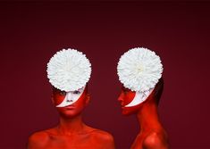 two women with red and white makeup are standing in front of each other, facing opposite directions